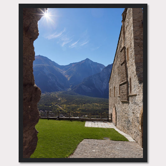 This captivating image showcases a stunning view of a mountainous landscape framed by the rustic stone walls of an ancient structure. The bright sun shines above, casting a warm glow over the scene.