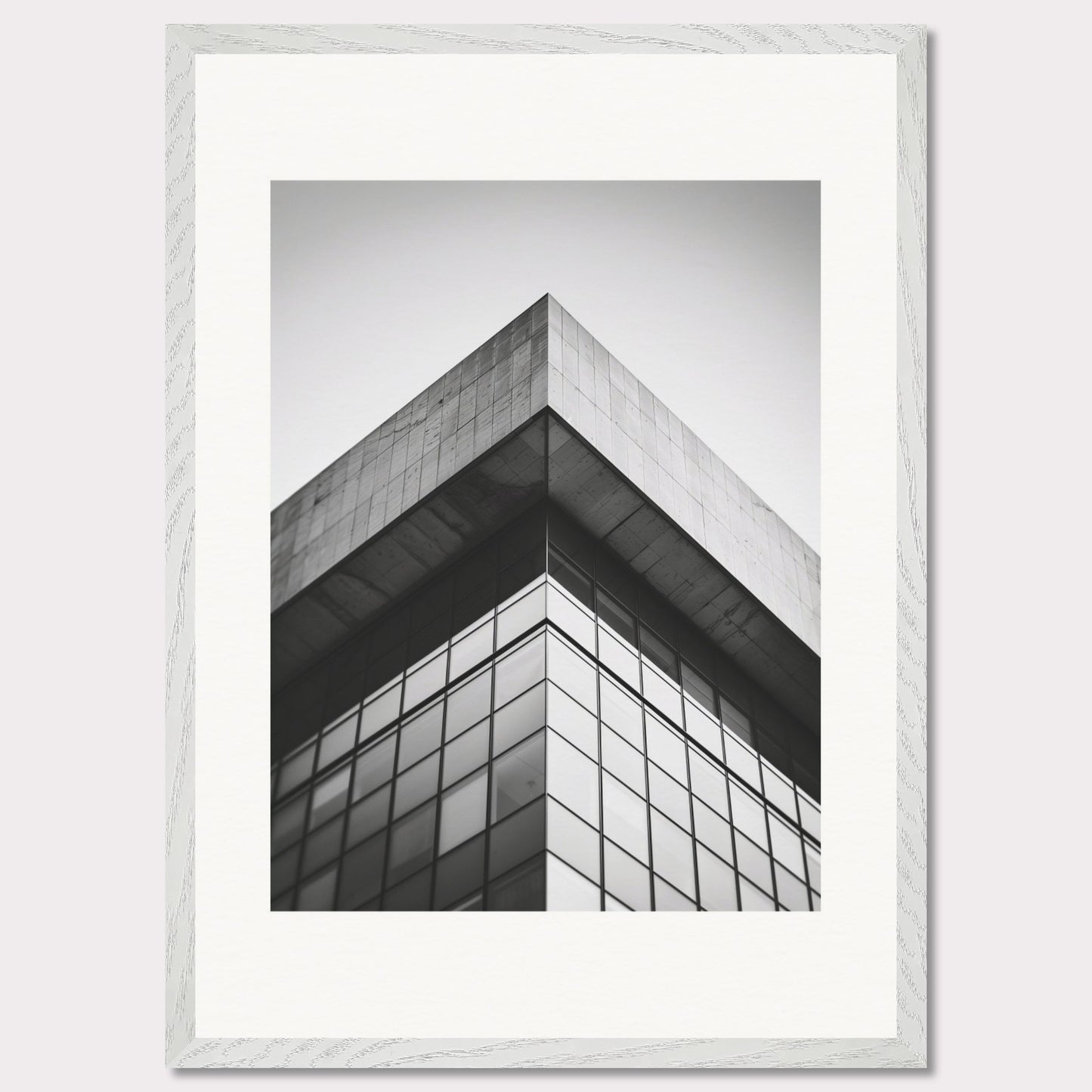 This striking black and white photograph captures the sharp, geometric lines of a modern architectural structure. The image focuses on the corner of a building, emphasizing its sleek glass windows and concrete elements.