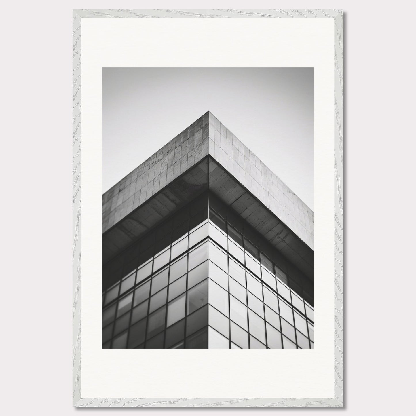 This striking black and white photograph captures the sharp, geometric lines of a modern architectural structure. The image focuses on the corner of a building, emphasizing its sleek glass windows and concrete elements.