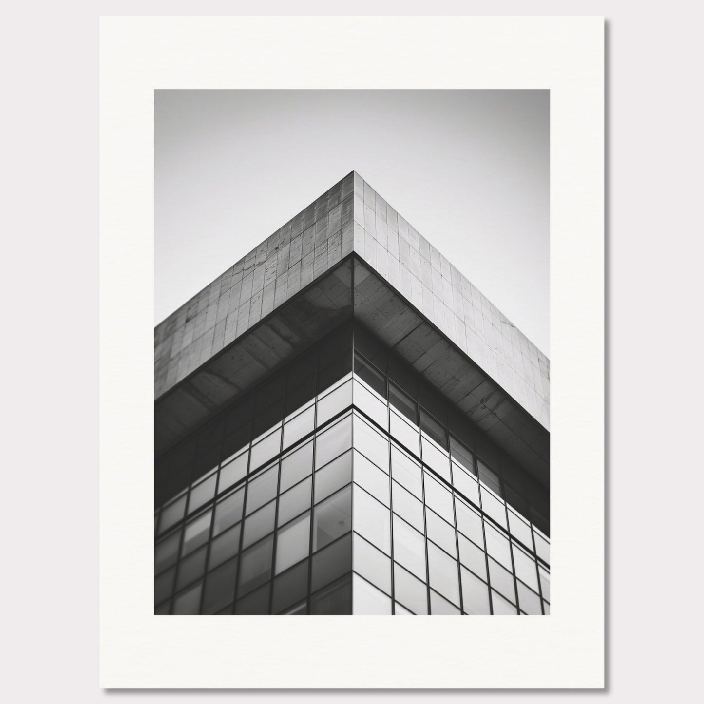 This striking black and white photograph captures the sharp, geometric lines of a modern architectural structure. The image focuses on the corner of a building, emphasizing its sleek glass windows and concrete elements.