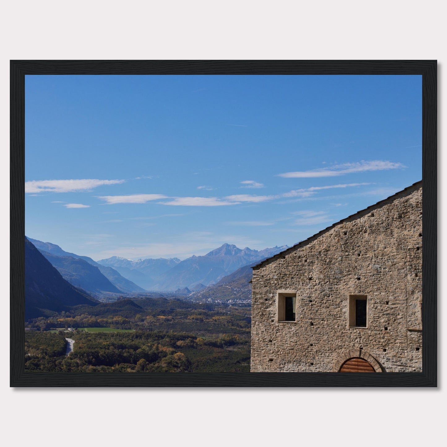 This stunning photograph captures a serene landscape with a historic stone building in the foreground and majestic mountains in the background.