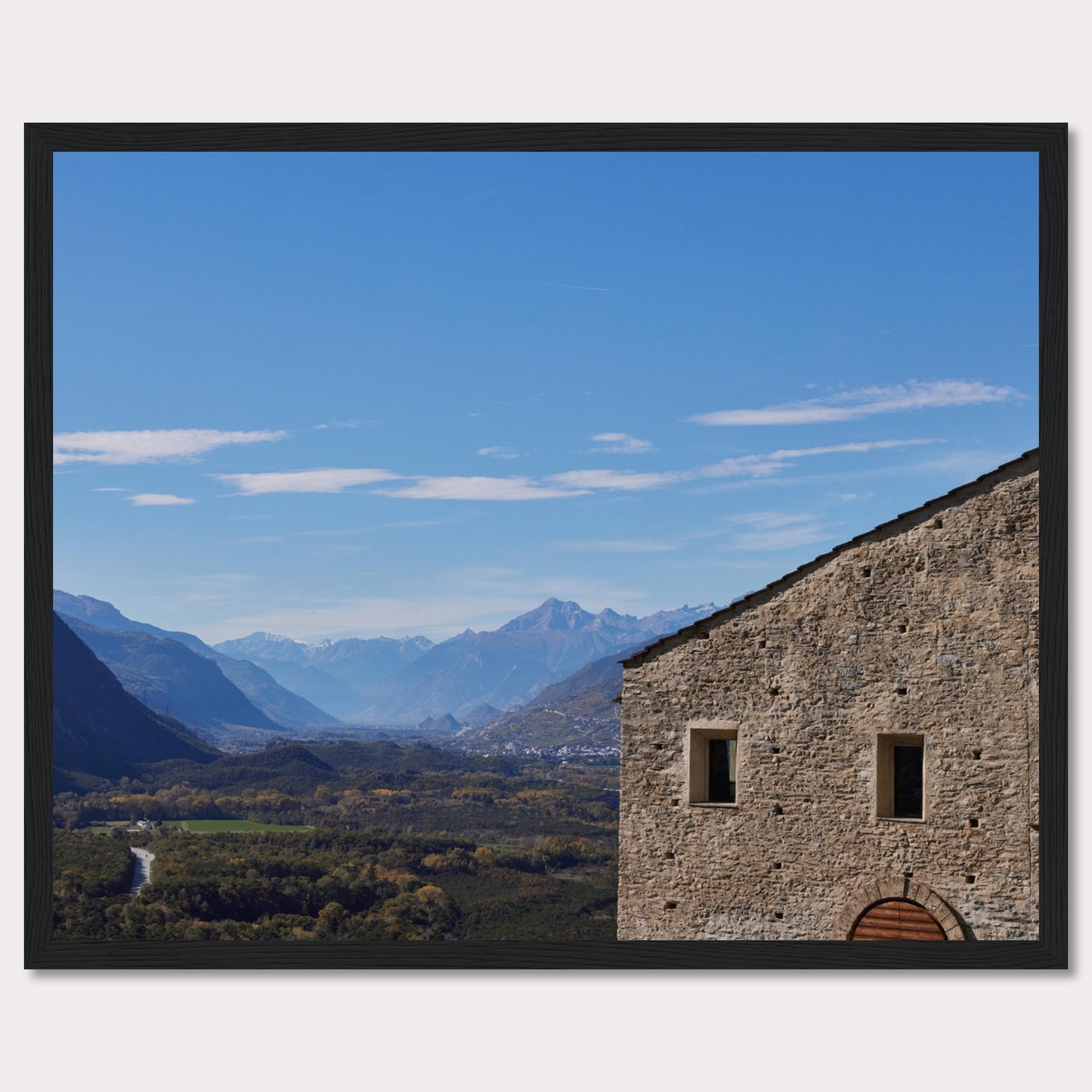 This stunning photograph captures a serene landscape with a historic stone building in the foreground and majestic mountains in the background.