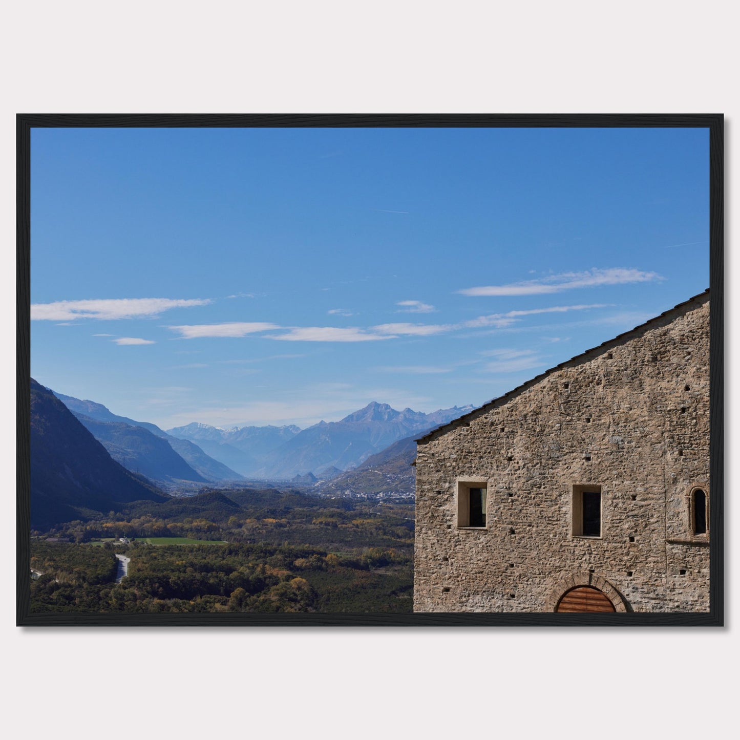 This stunning photograph captures a serene landscape with a historic stone building in the foreground and majestic mountains in the background.